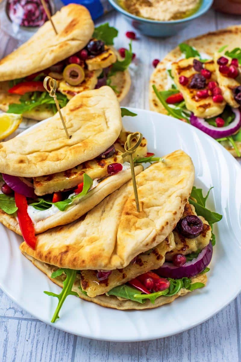 Two Grilled Halloumi flatbreads on a white plate.