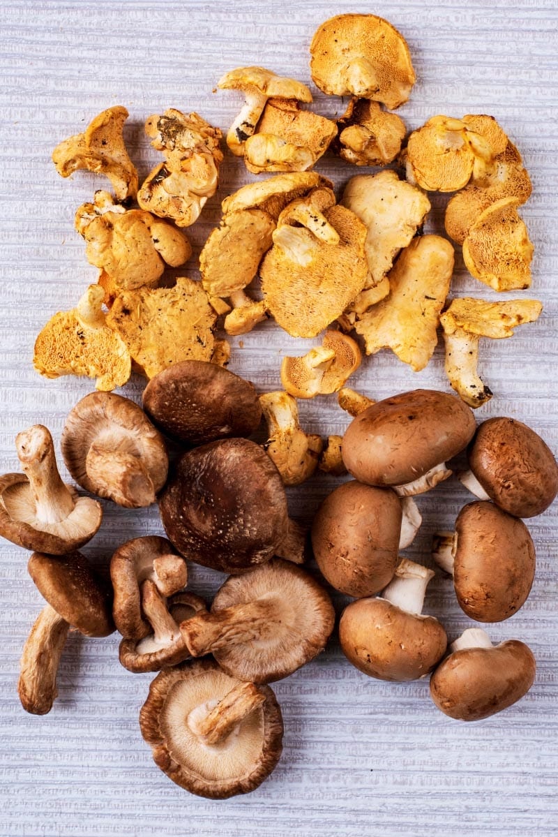 A selection of mushrooms on a wooden surface.