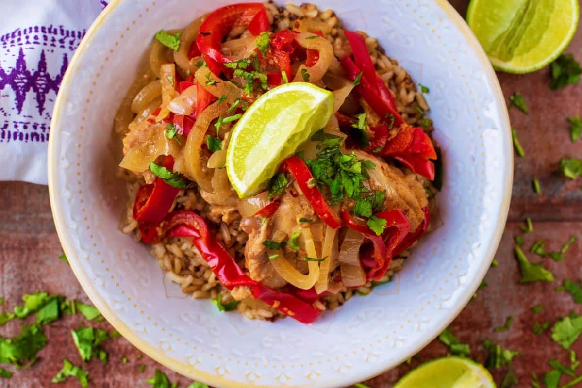 Slow Cooker Thai Chicken Curry in a white bowl, topped with a lime wedge.