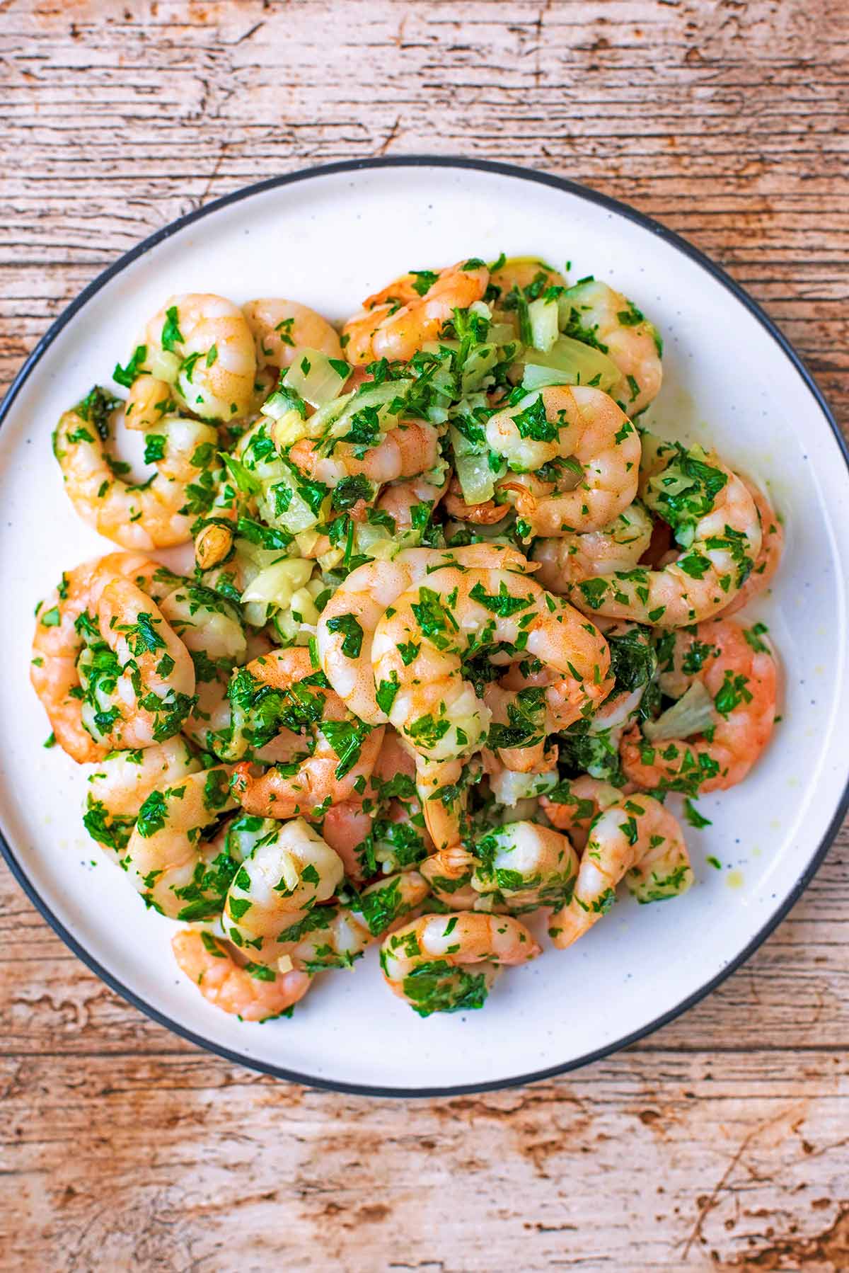 Air fried king prawns on a plate with herbs.
