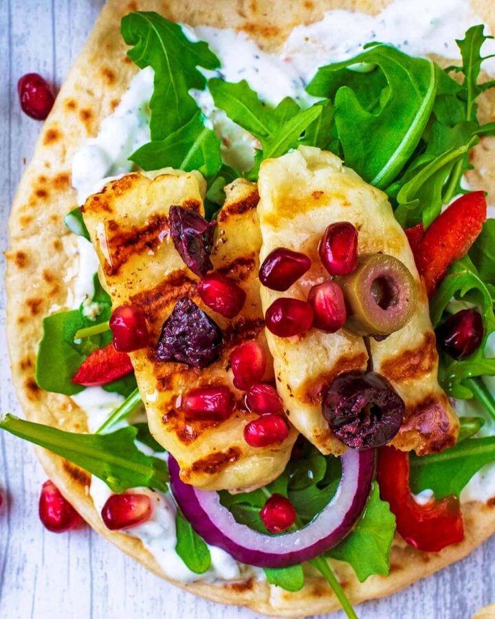 A flatbread spread with tzatziki then lettuce, halloumi and chopped olives added.