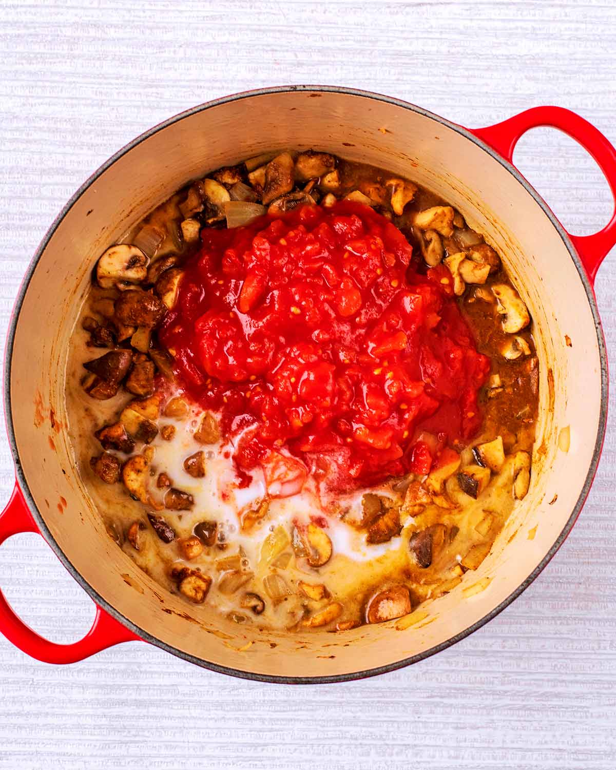 Chopped tomatoes and coconut milk added to the pan.