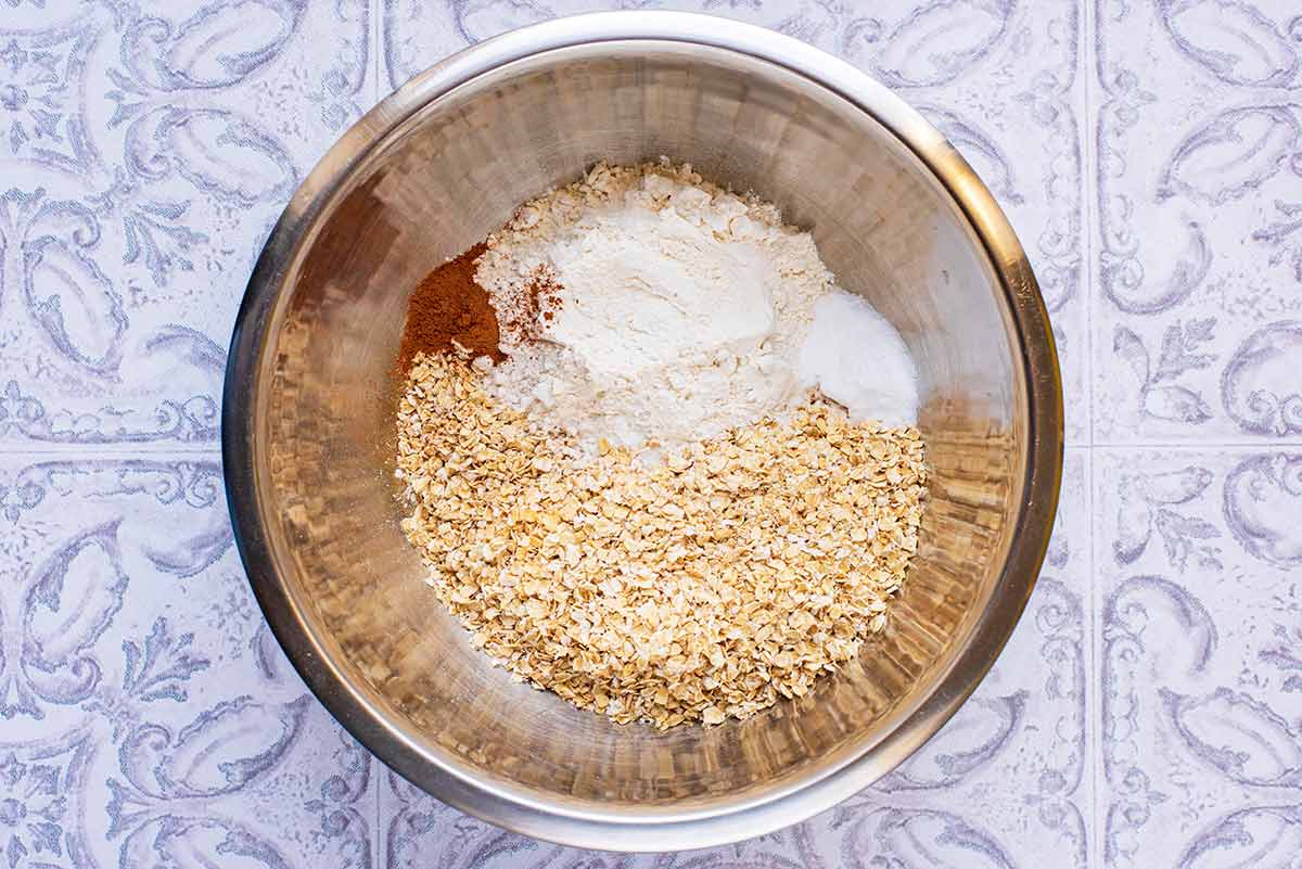 Oats, flour, ginger, baking powder and cinnamon in a mixing bowl.