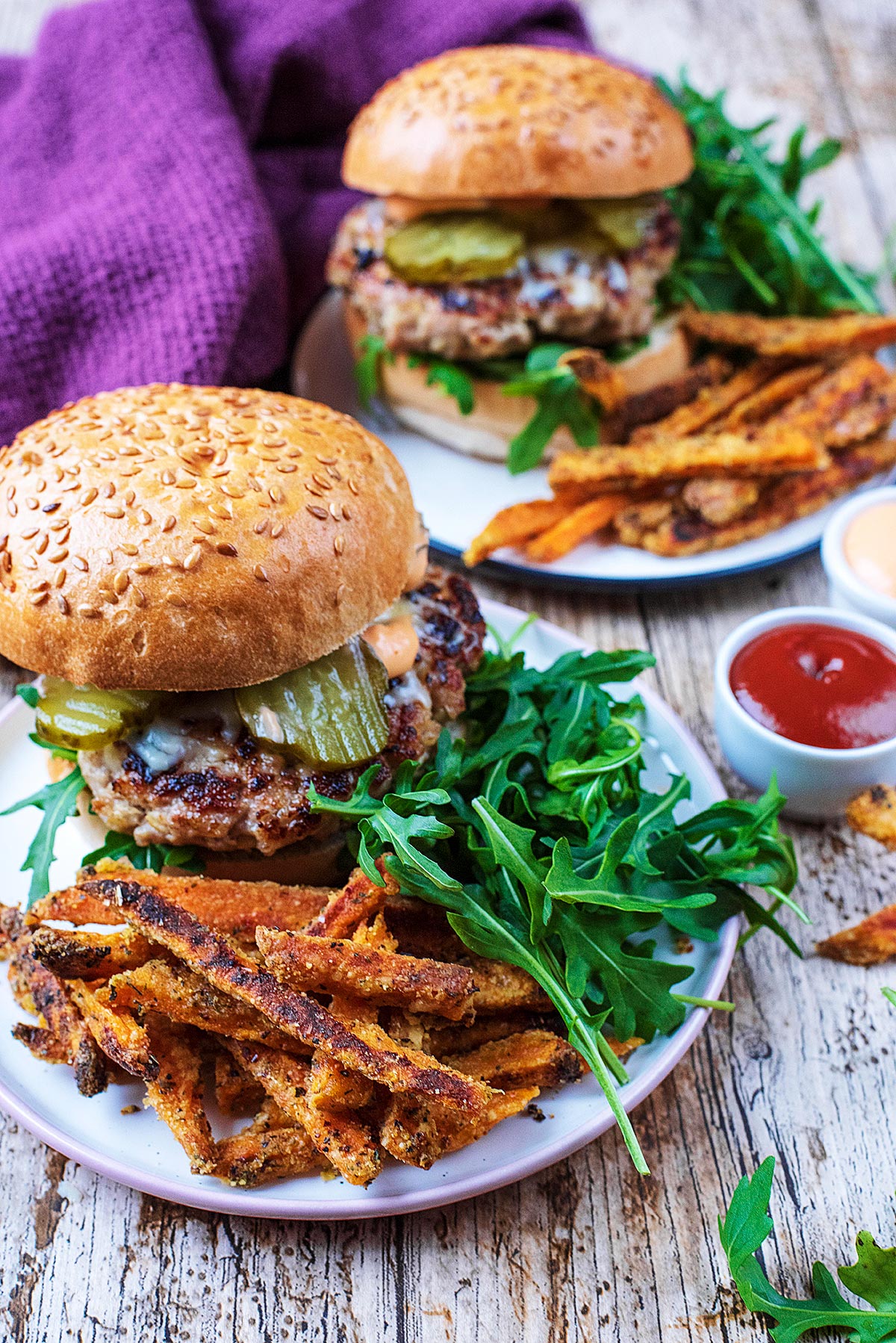 Two Pork and Apple Burgers with sweet potato fries and salad