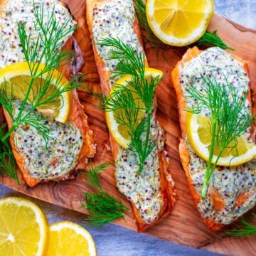 Creamy Dill Salmon topped with lemon slices and sprigs of dill.