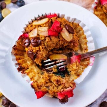 A healthy banana oat muffin being cut open with a fork.