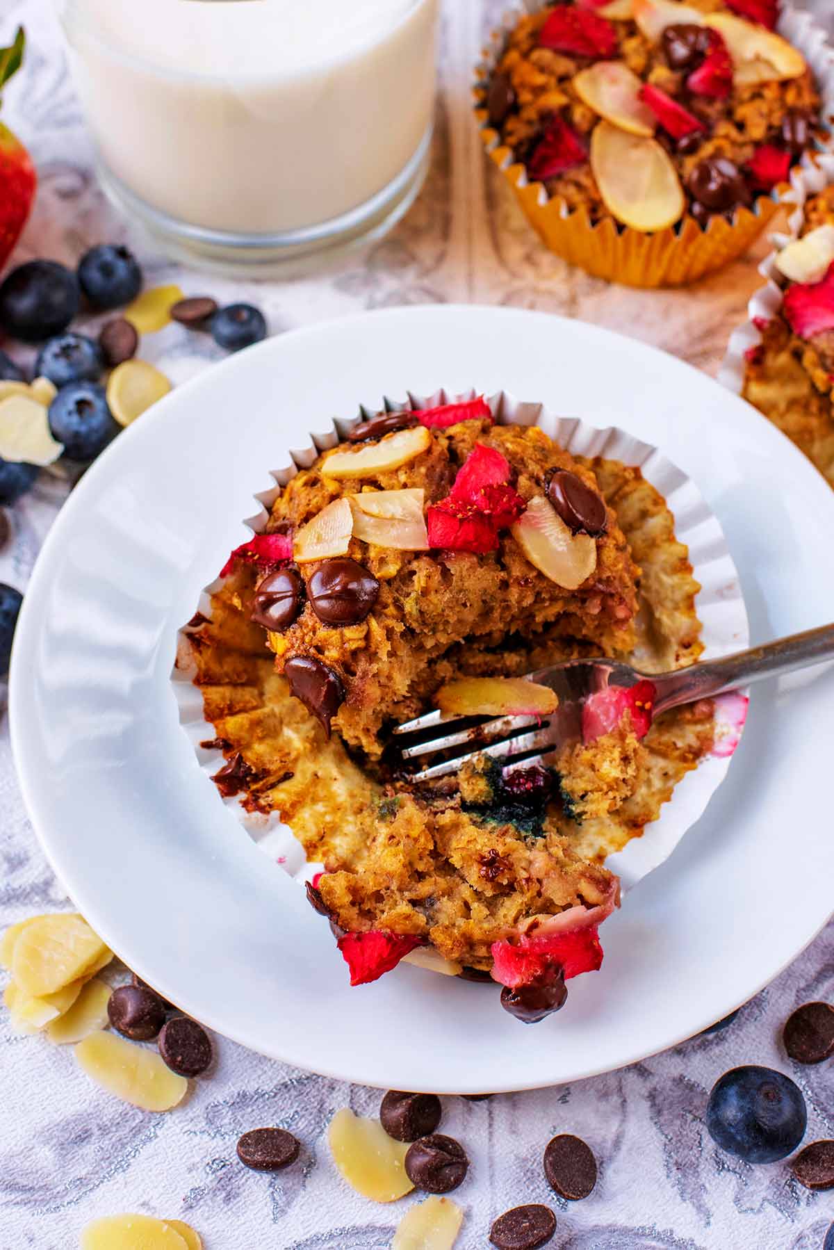 A fruit muffin being cut with a fork.
