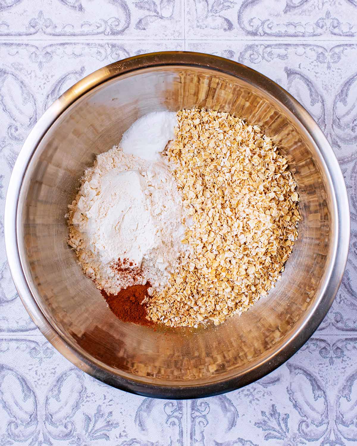 Oats, flour, ginger, baking powder and cinnamon in a mixing bowl.