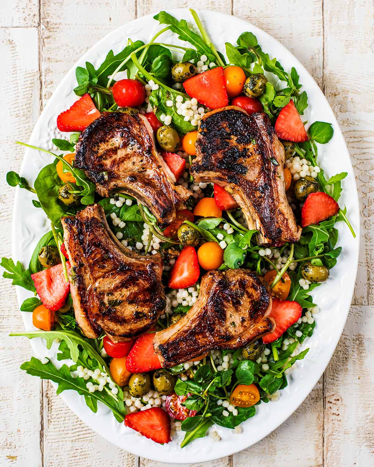 Cooked lamb chops addes on top of the salad.