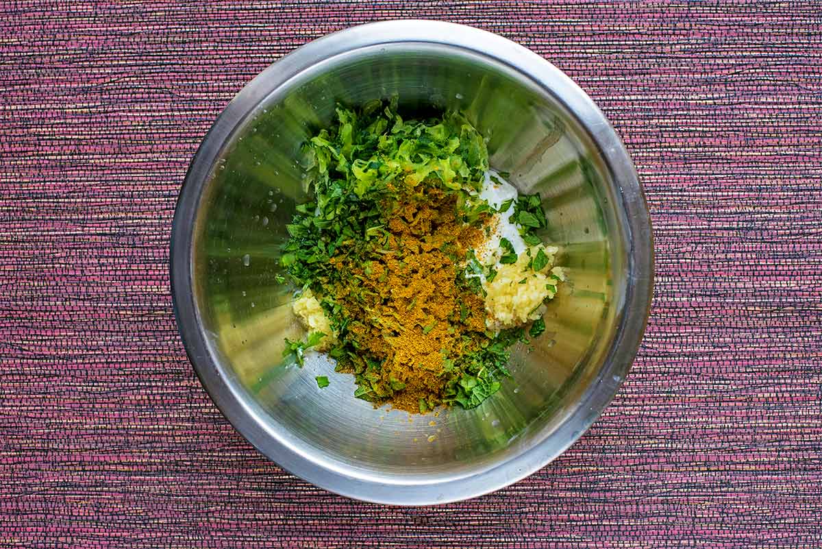 Yogurt, chopped mint, garlic ginger and spices in a mixing bowl.