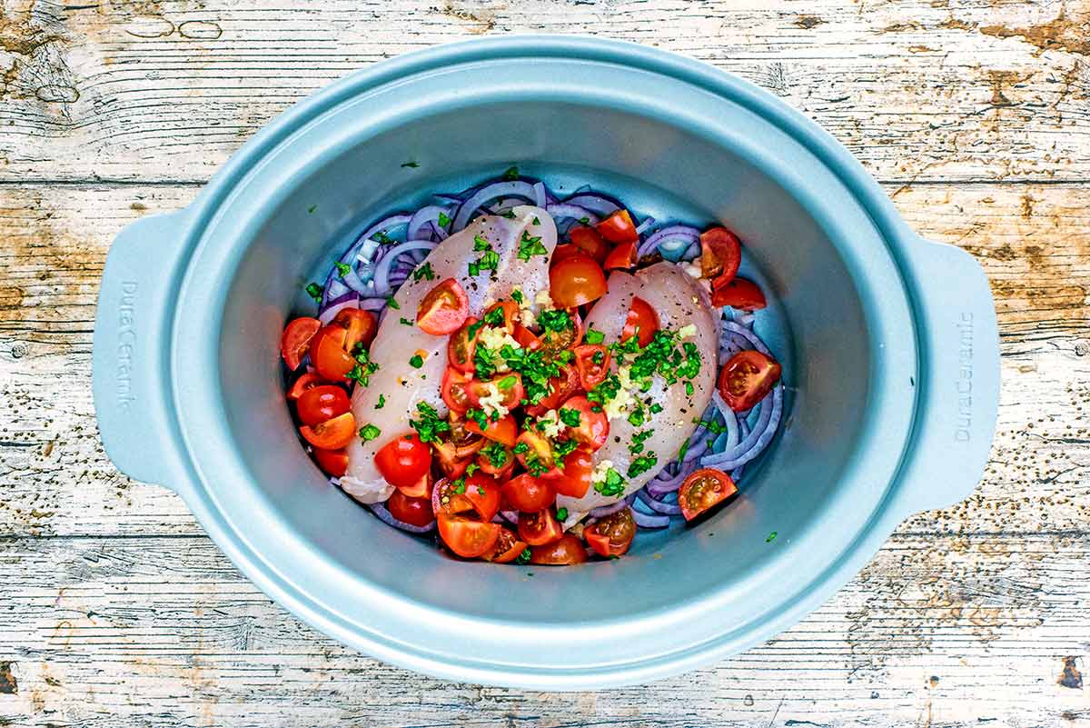 Chopped tomatoes, crushed garlic and chopped herbs added to the slow cooker.