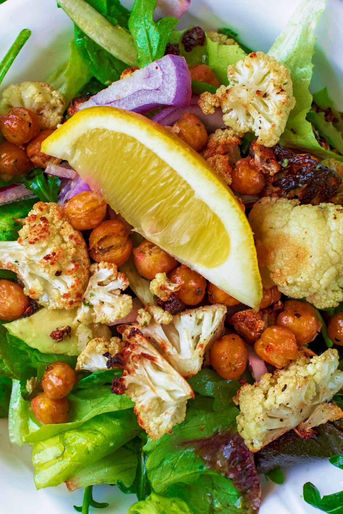 A lemon wedge sat on top of roasted cauliflower and chickpeas.
