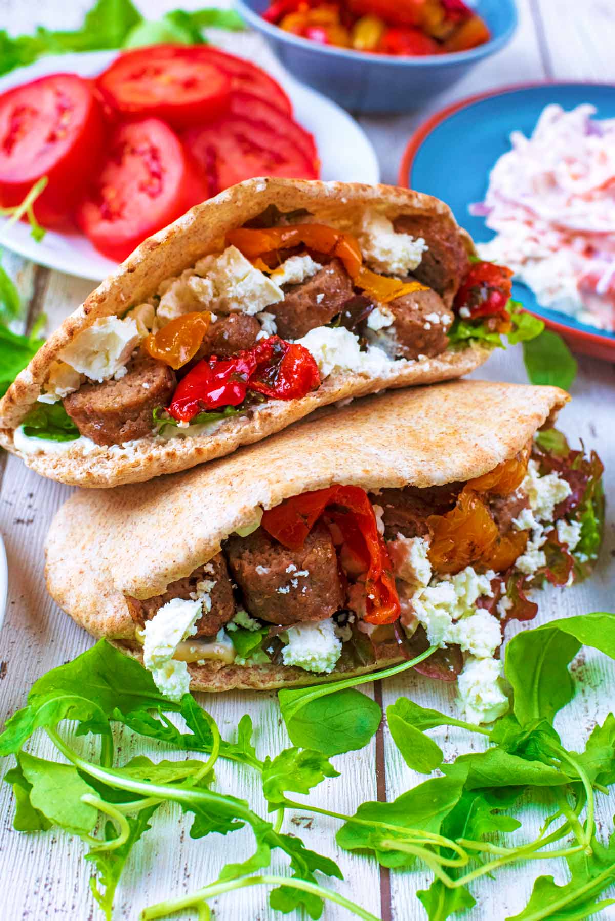 Two open pita breads stuffed with lamb and salad.