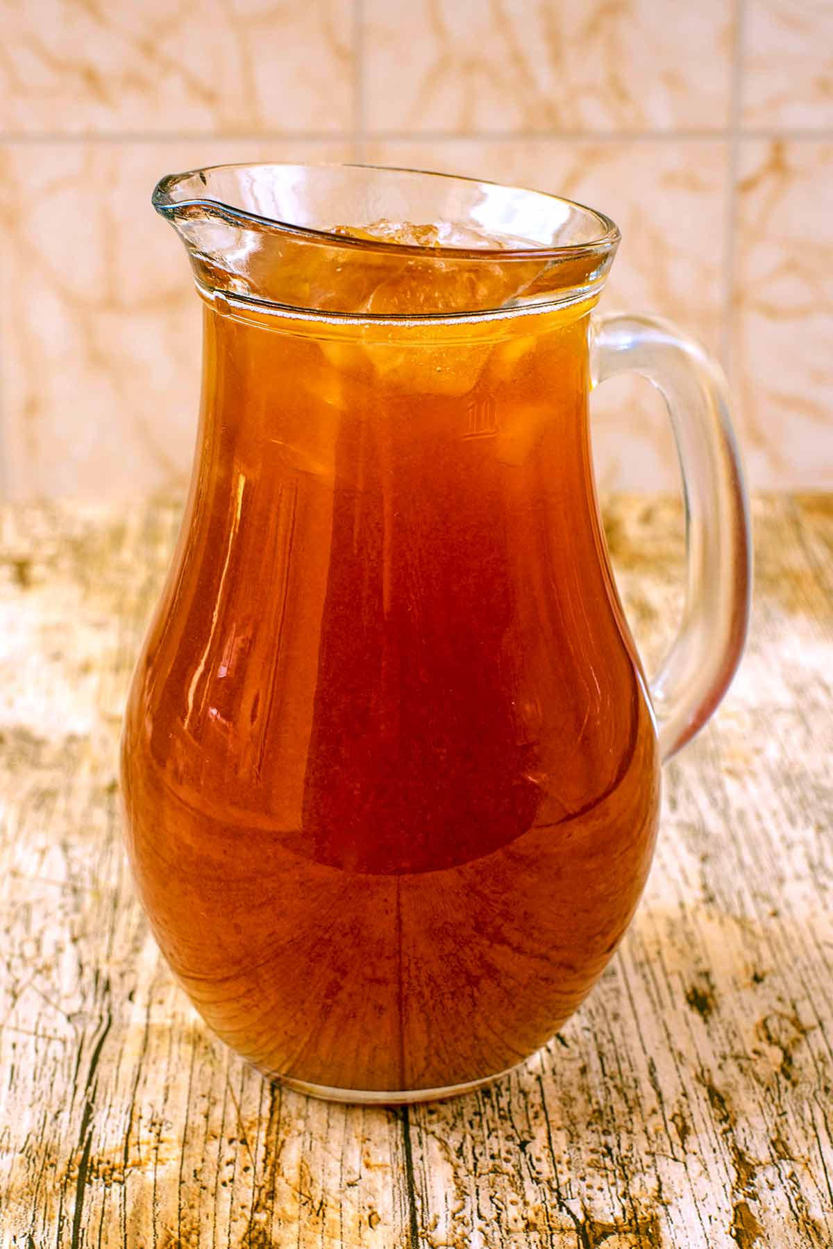 A glass jug full of iced tea.