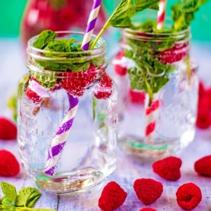 Raspberry and mint water in two mason jars.