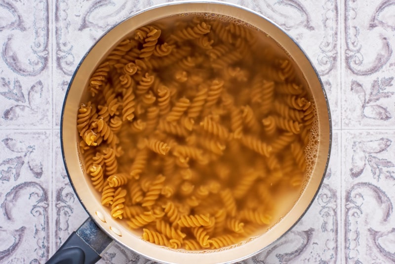 A saucepan containing cooked fusilli pasta.