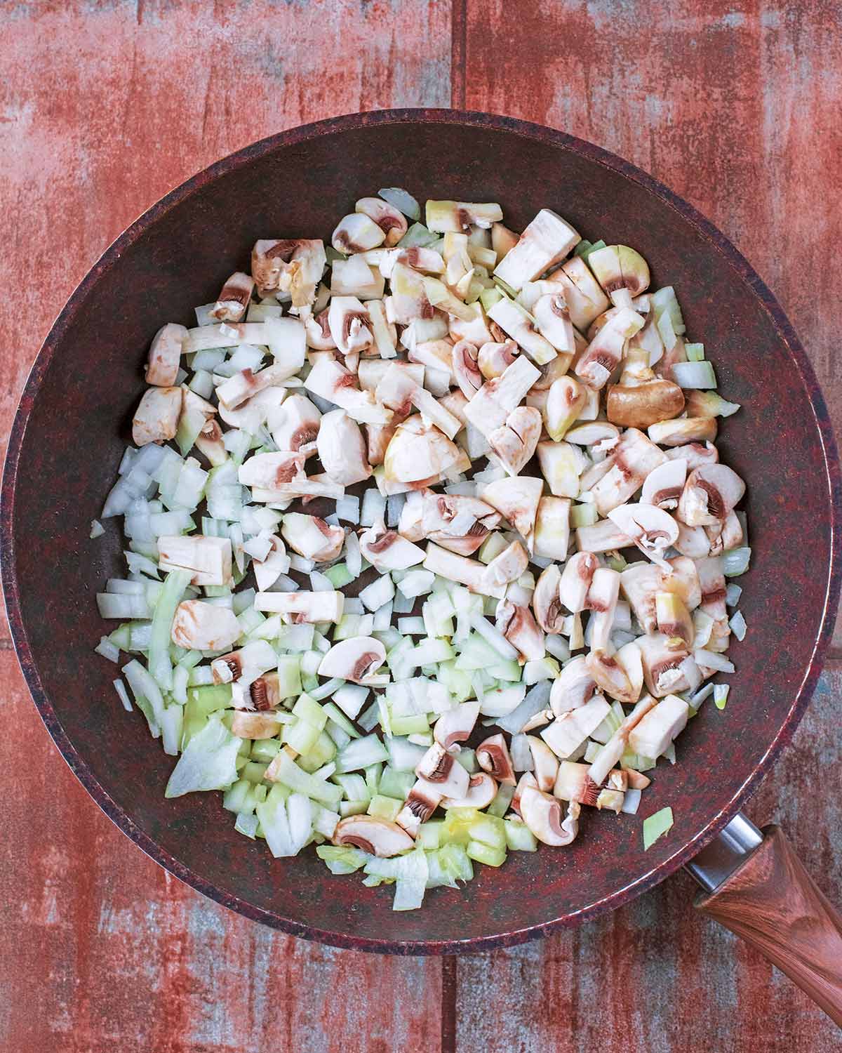 Chopped onion, mushrooms and garlic in a frying pan.