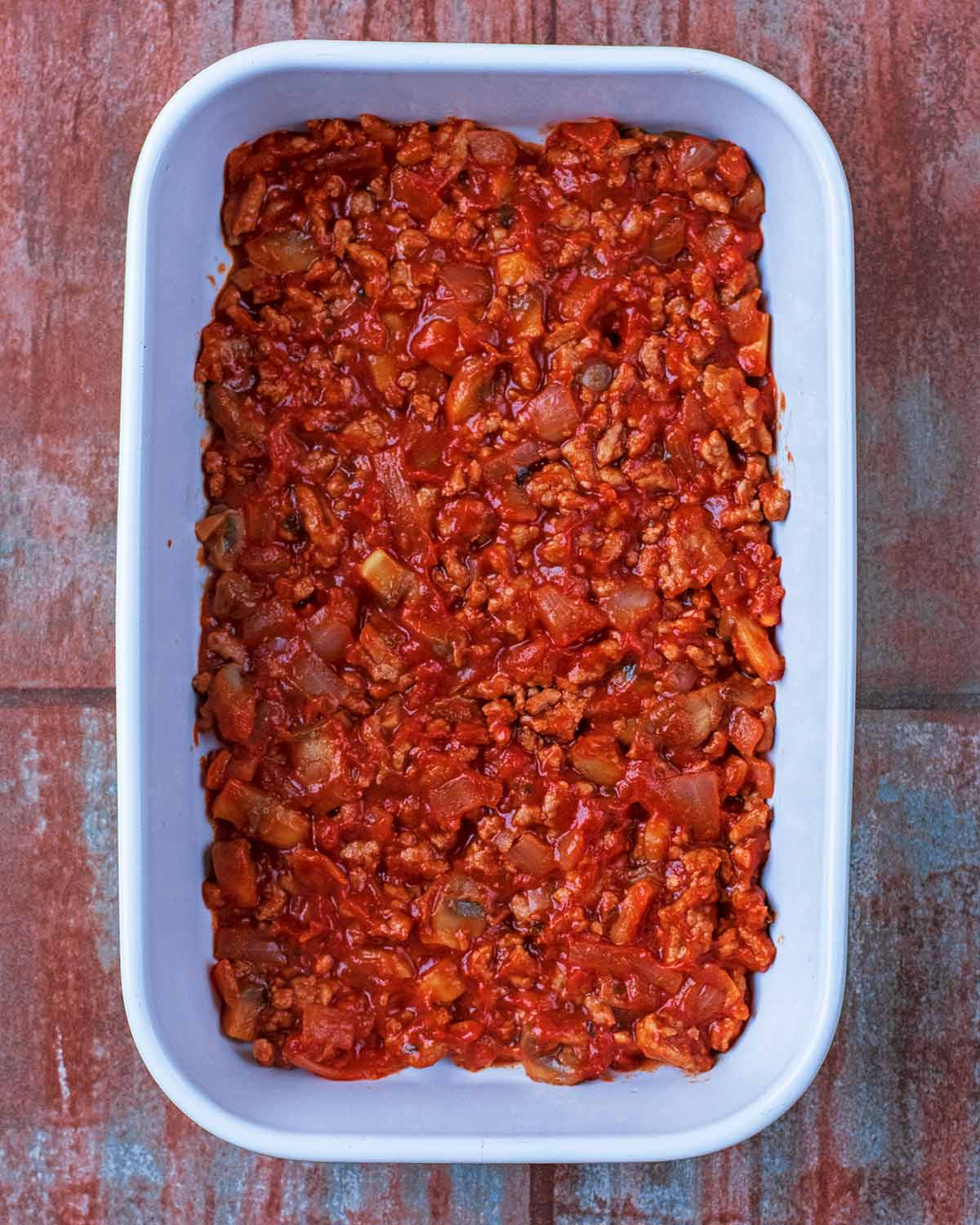 A baking dish containing a tomato meat sauce.