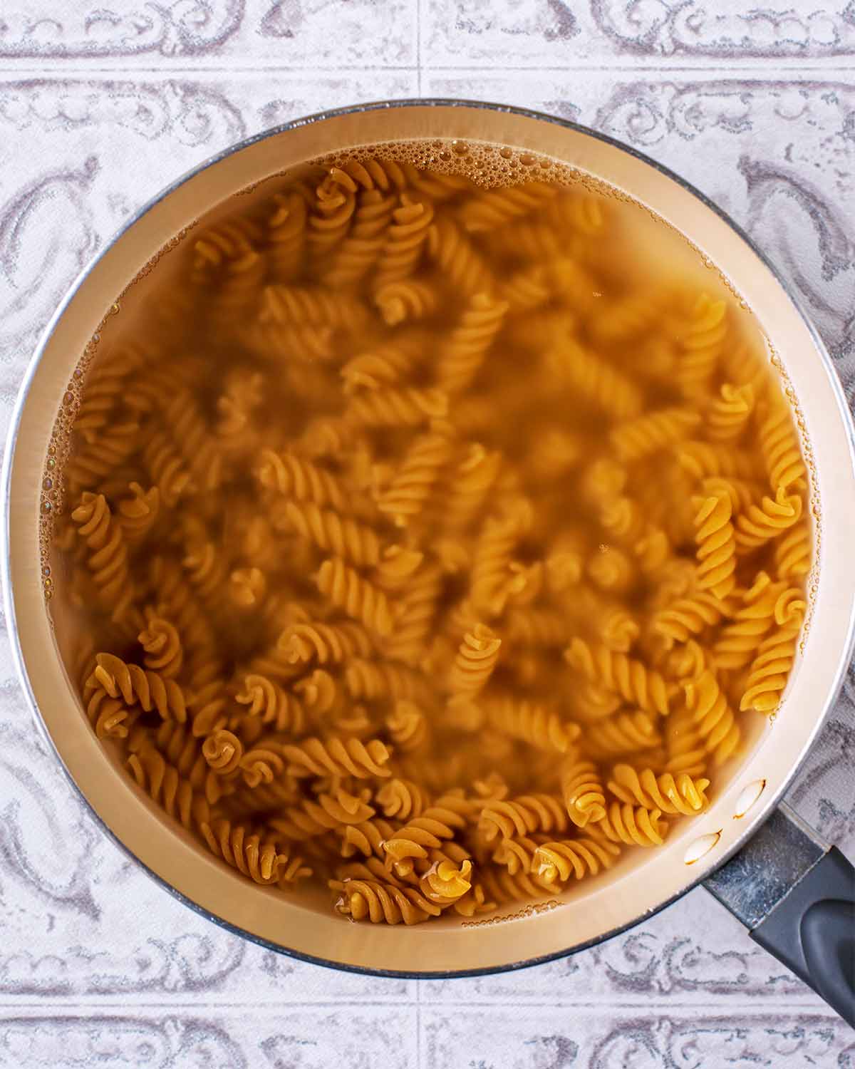 A saucepan containing cooked fusilli pasta.