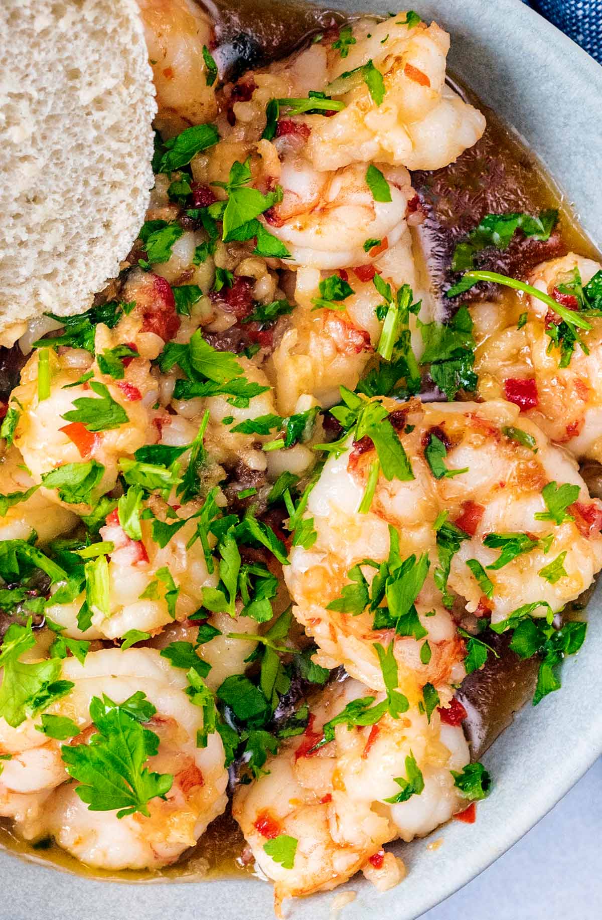 Cooked prawns with chopped herbs scattered over them.
