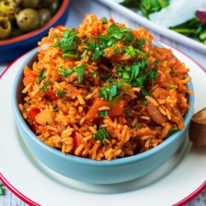Spanish Rice in a blue bowl topped with chopped parsley