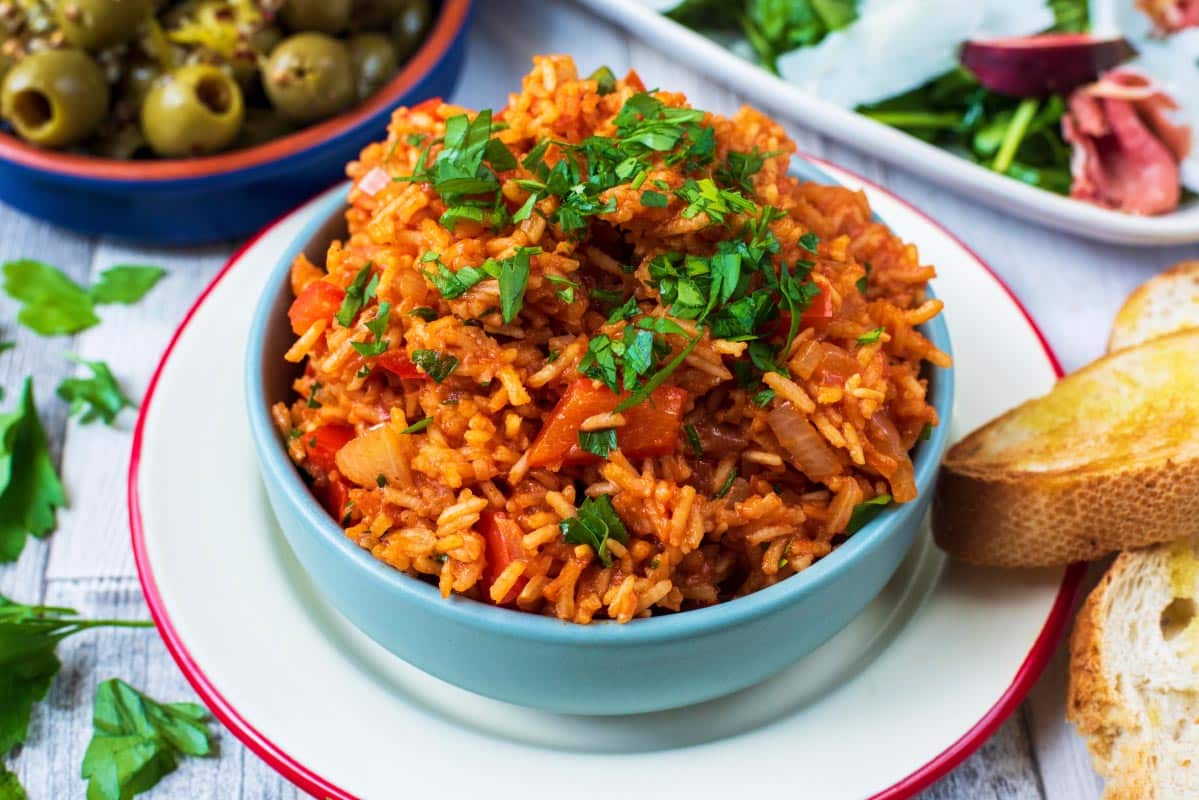 Spanish Rice in a blue bowl topped with chopped parsley.