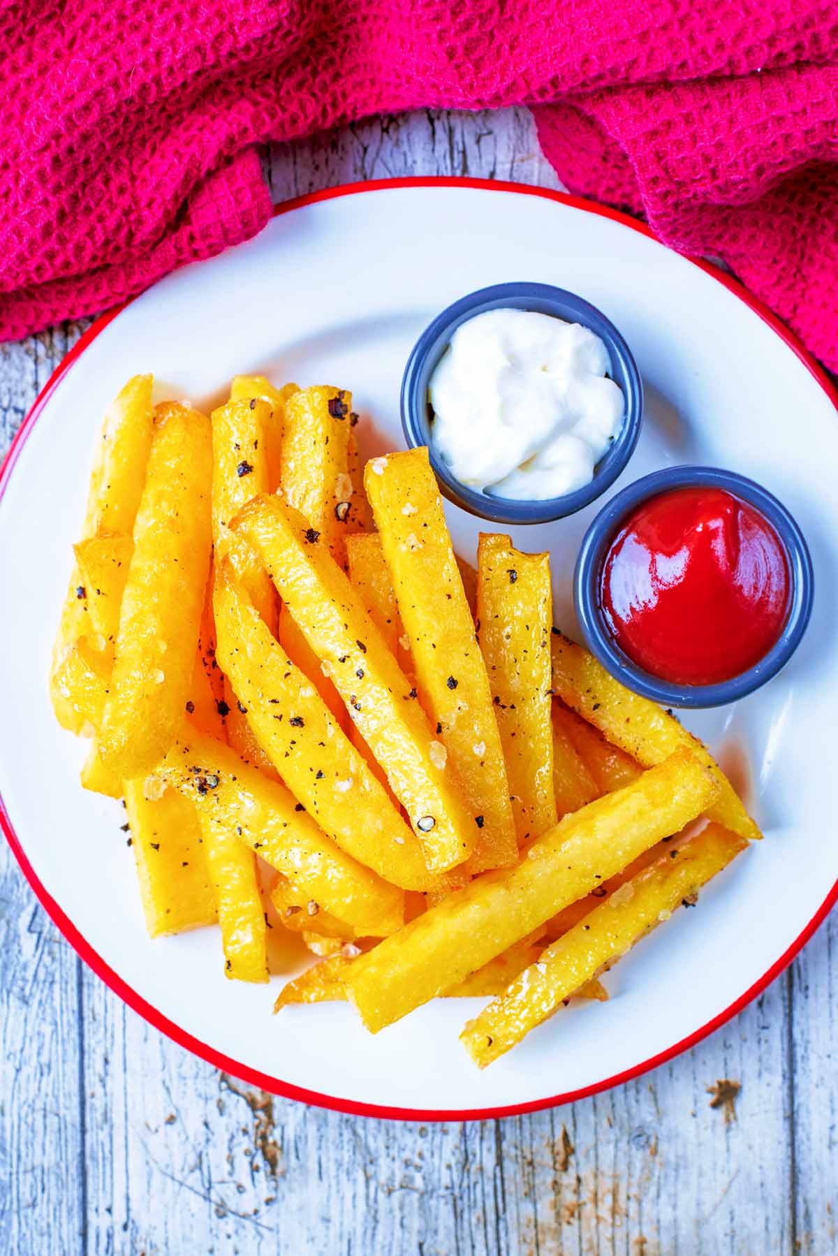 A plate of polenta fries next to a red towel.