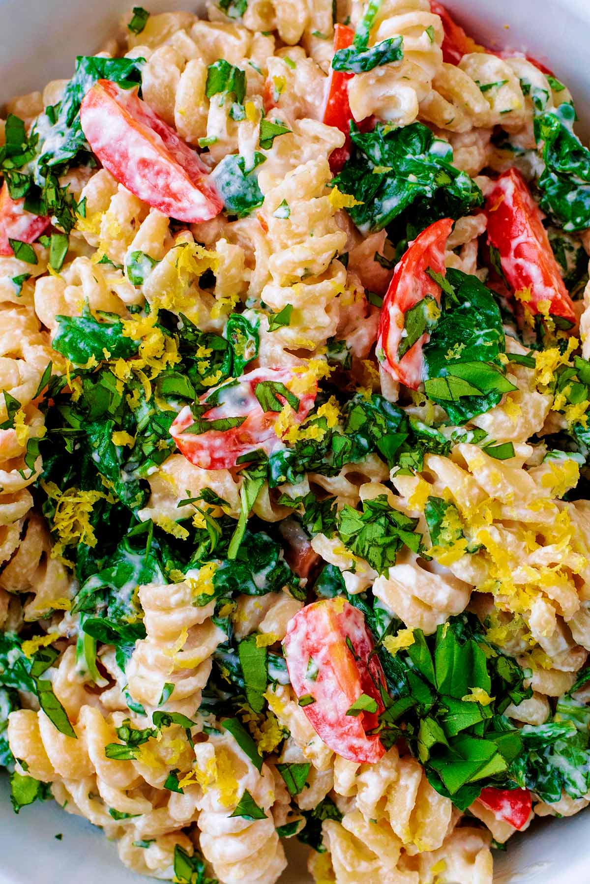 Pasta, spinach, tomatoes and lemon zest mixed together.