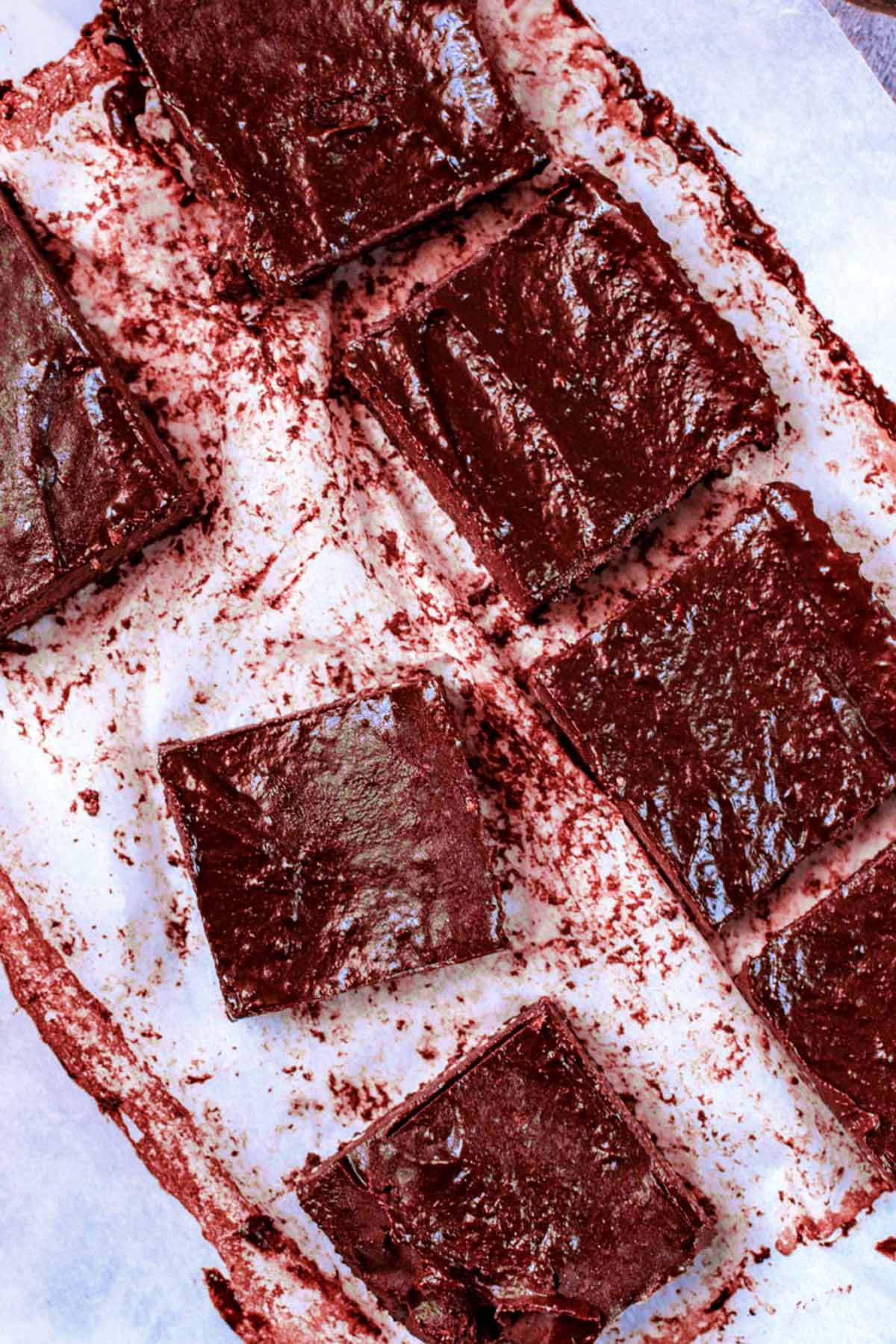 Chocolate brownies cut into squares on a sheet of baking paper.
