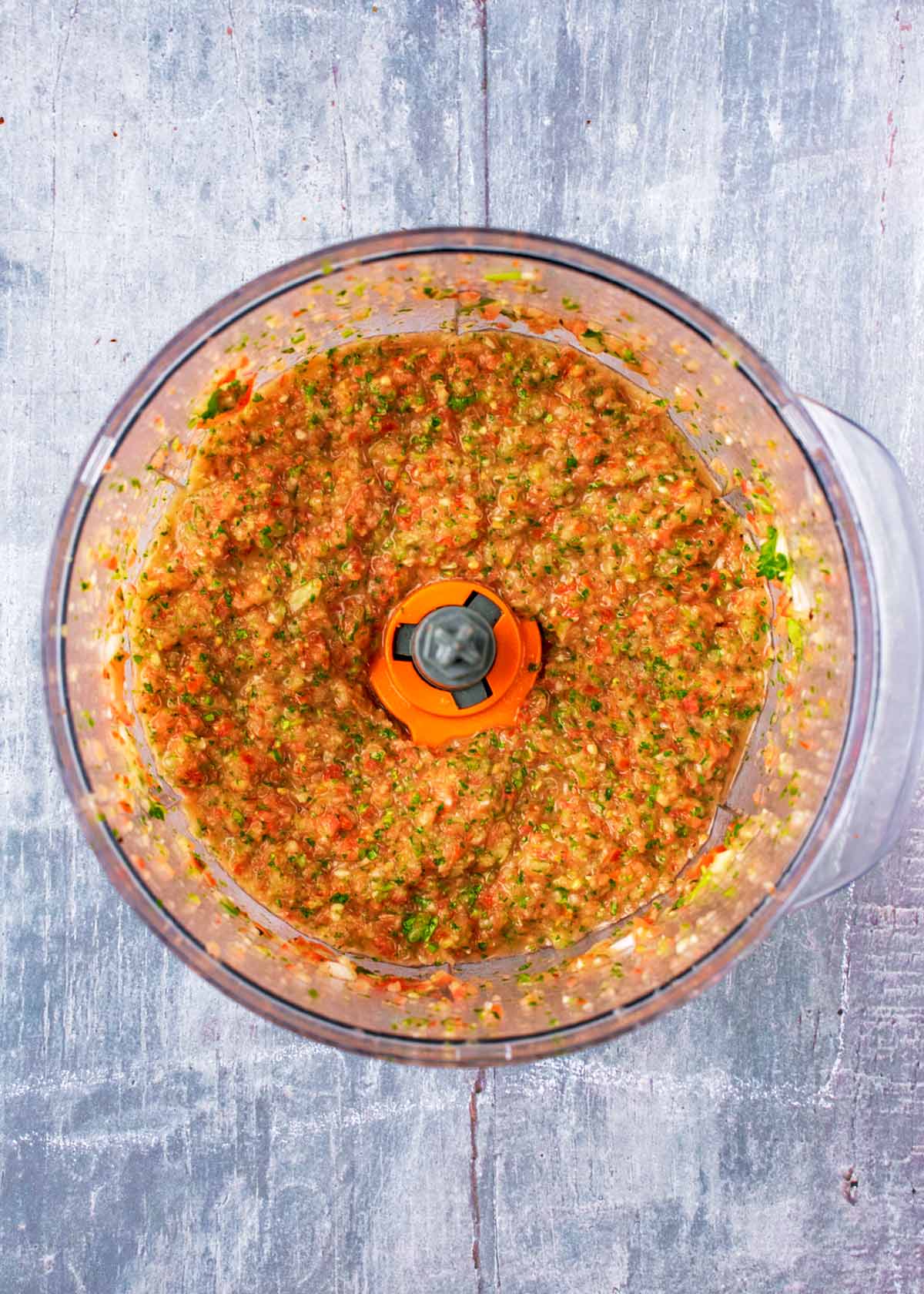 A food processor containing a finely chopped salsa.