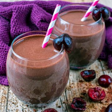 Two glasses of Chocolate Cherry Smoothie next to a purple towel.
