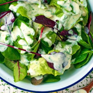 Healthy Ranch Dressing drizzled over lettuce leaves.
