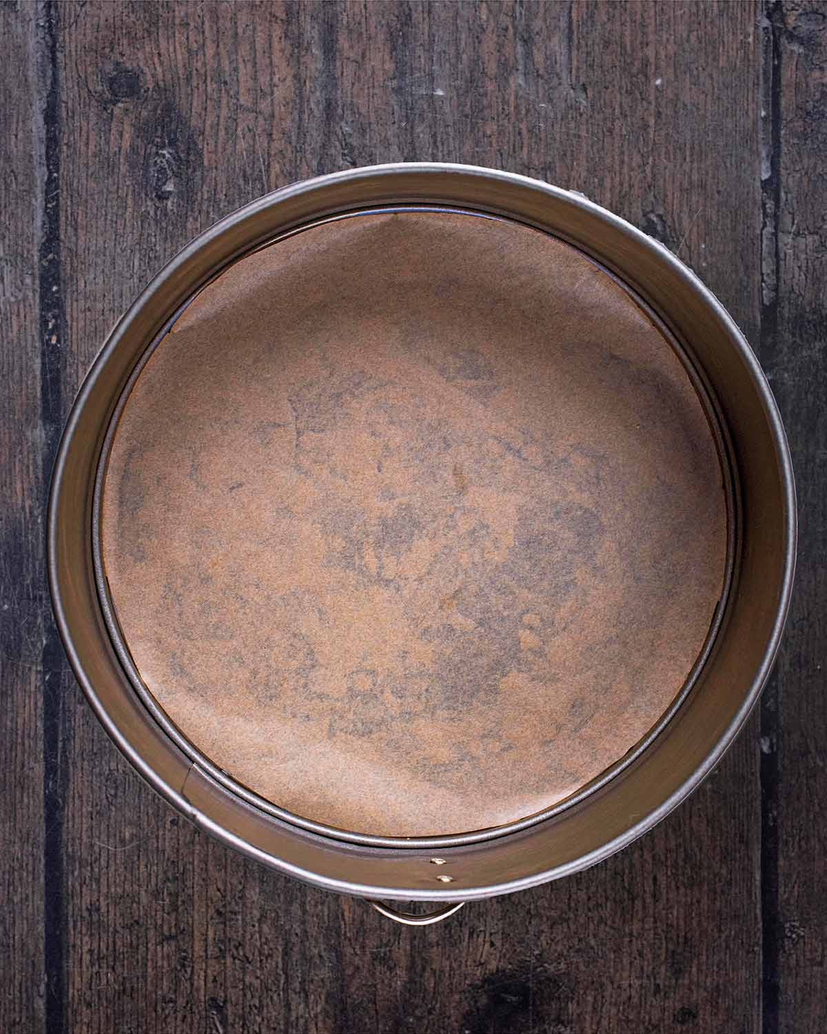 A round baking tin lined with parchment paper.