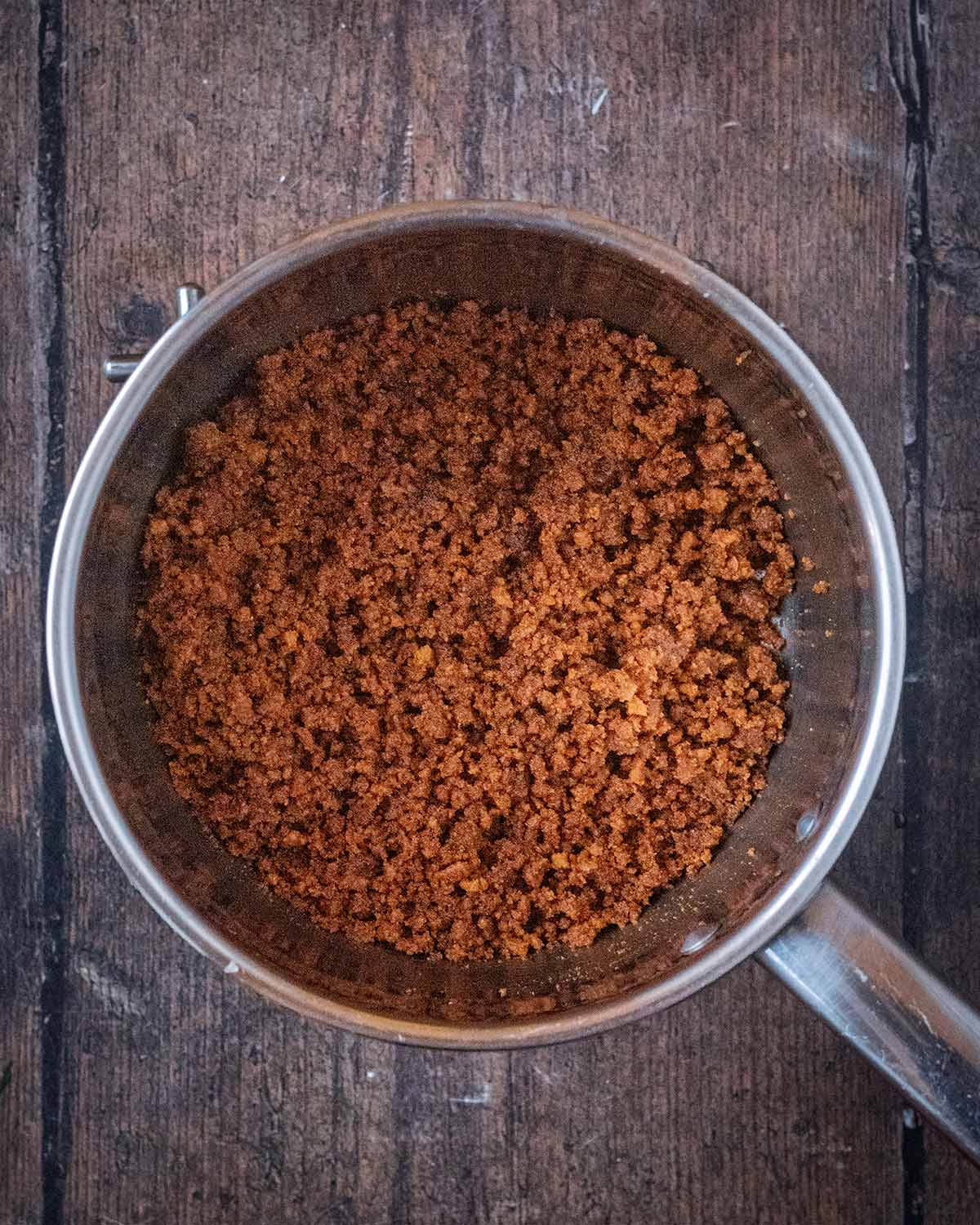 Crushed biscuits added to the melted butter.