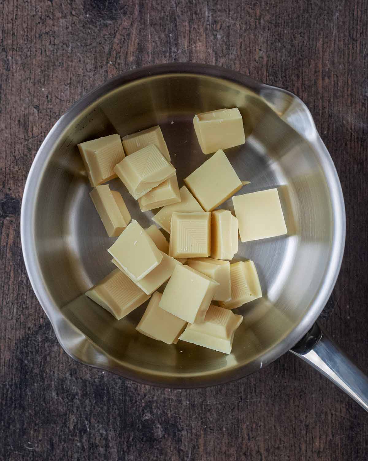 Chunks of white chocolate in a saucepan.