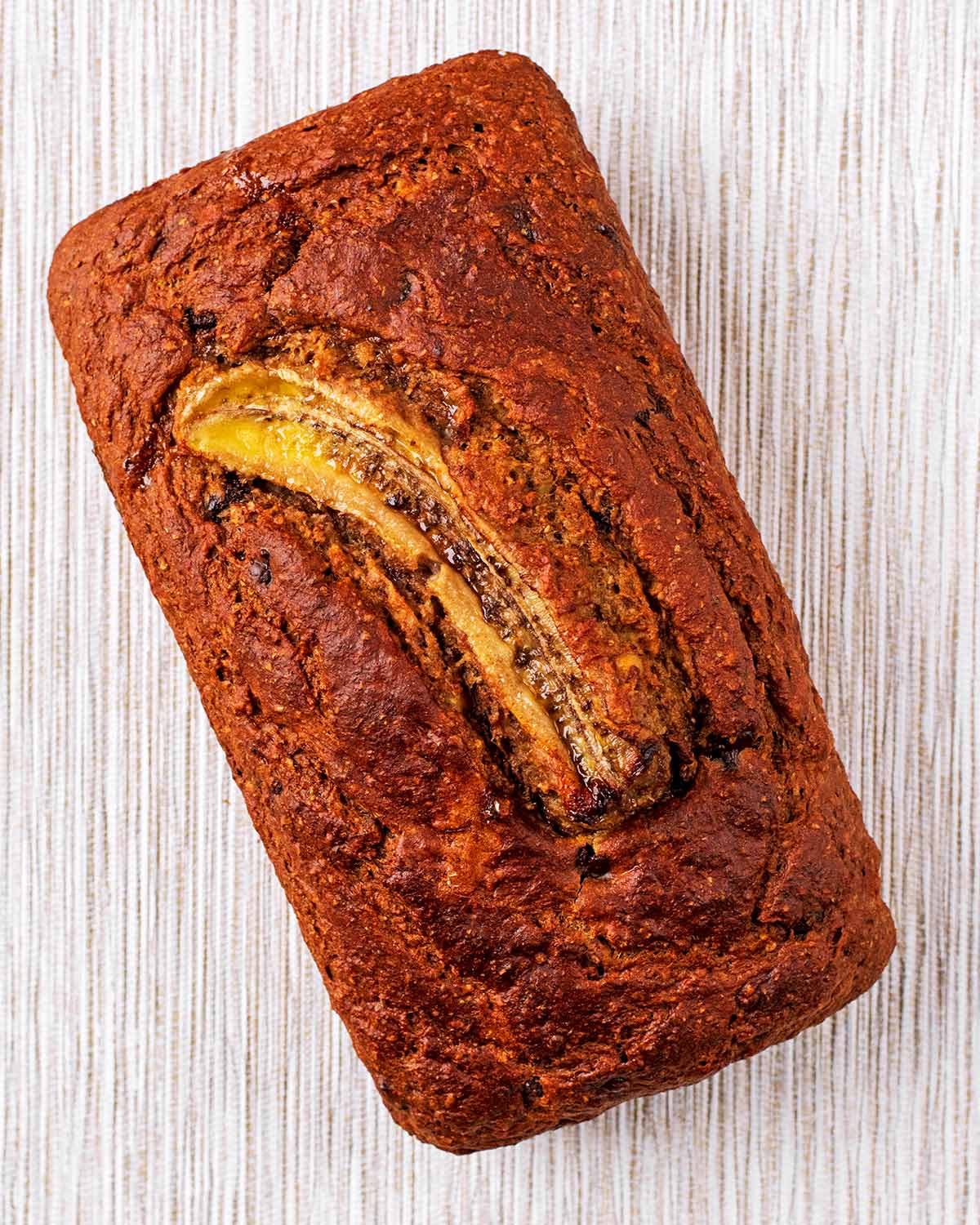 Cooked banana bread with a sliced banana on top.