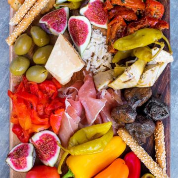 An antipasto platter containing fruit, vegetables, cheese and meats.
