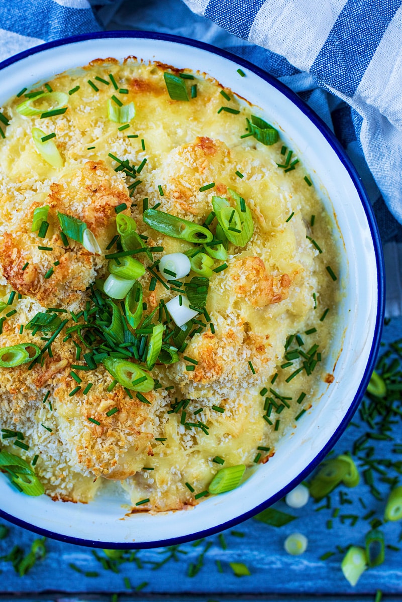 A white bowl full of baked cauliflower cheese