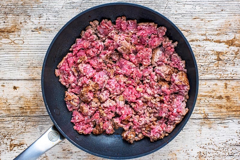 a frying pan with part cooked beef mince