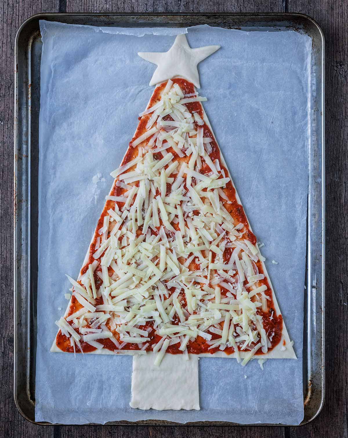 Grated cheese added to the pizza.