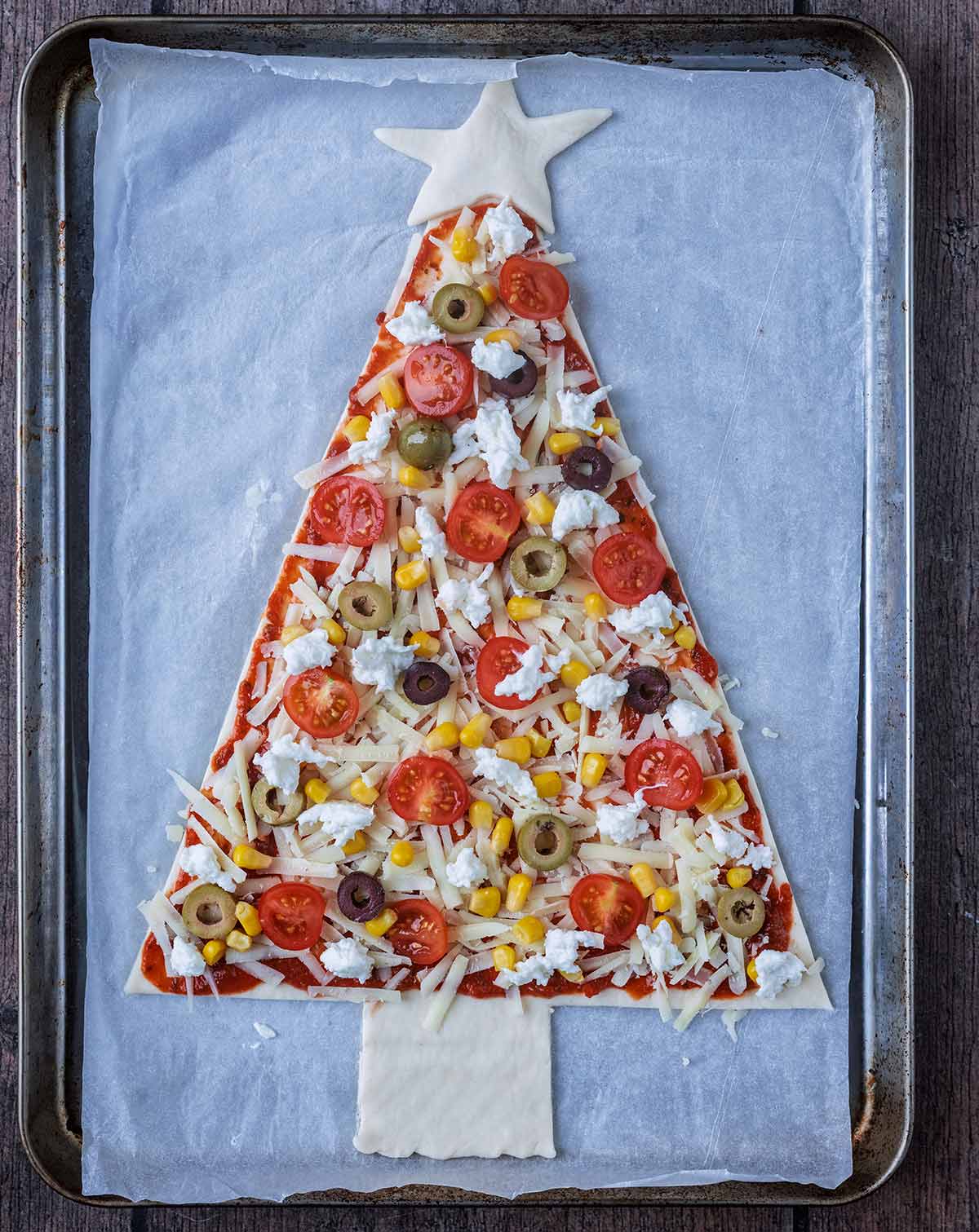 Sliced tomatoes, sliced olives, sweetcorn and torn mozzarella added on top of the cheese.