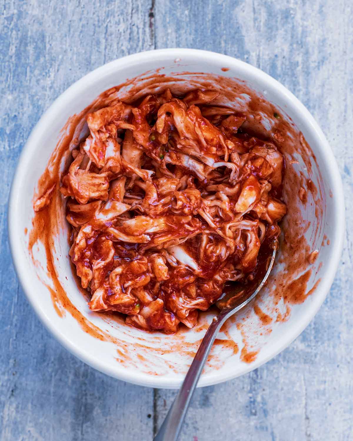 A small bowl of shredded turkey in a barbecue sauce.