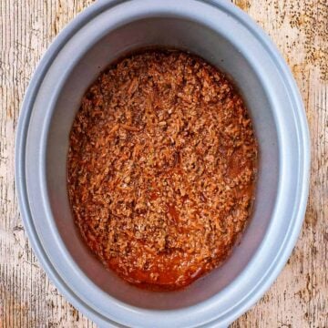 Slow cooker bolognese in a silver slow cooker bowl.
