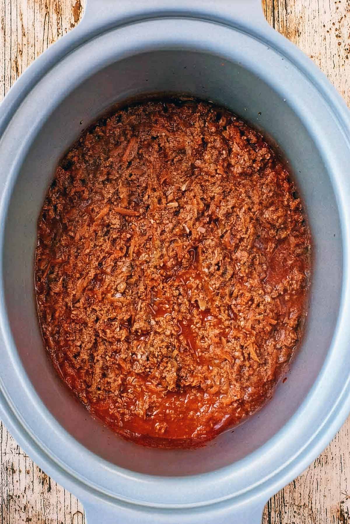 Slow cooker bolognese in a silver slow cooker bowl.