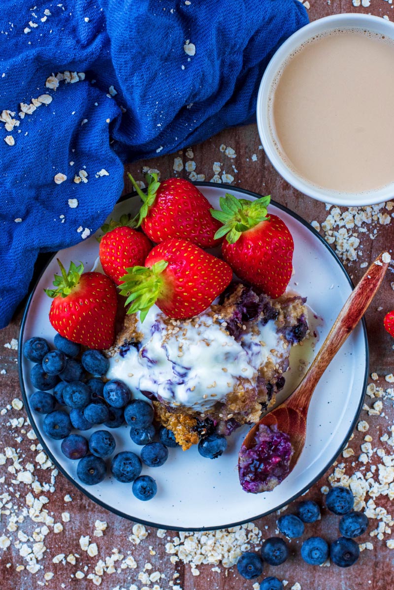 A plate of baked oats with yoghurt, blueberries and strawberries.