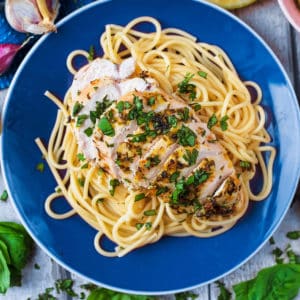 Lemon Basil Chicken and spaghetti on a blue plate.