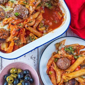 A tray of meatball pasta bake next to a plate of some more pasta bake