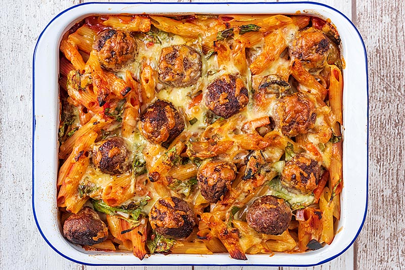 Meatball pasta bake, fresh from the oven with melted cheese covering the top