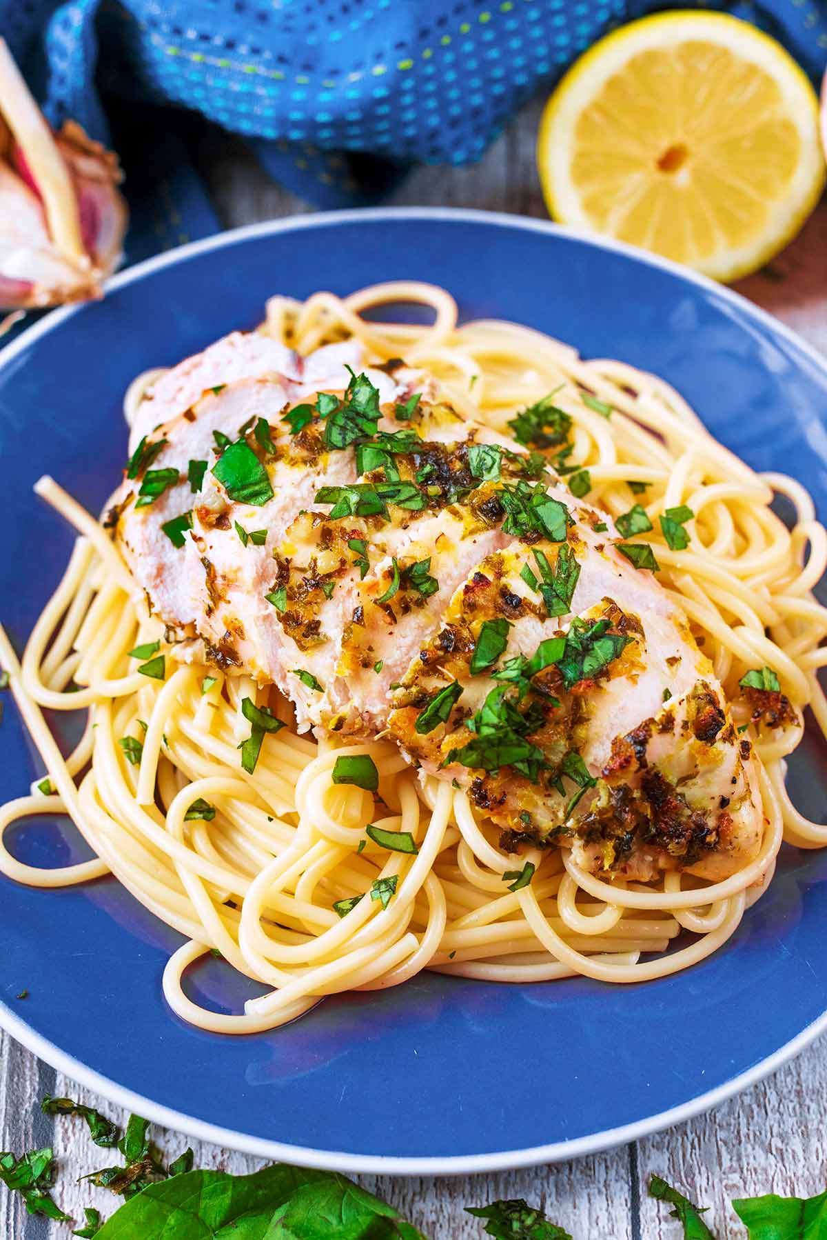 A plate of spaghetti and lemon basil chicken.