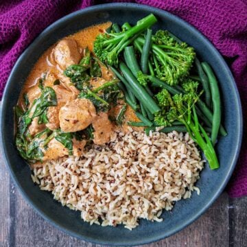 Slow cooker Thai chicken curry in a bowl with rice and broccoli.